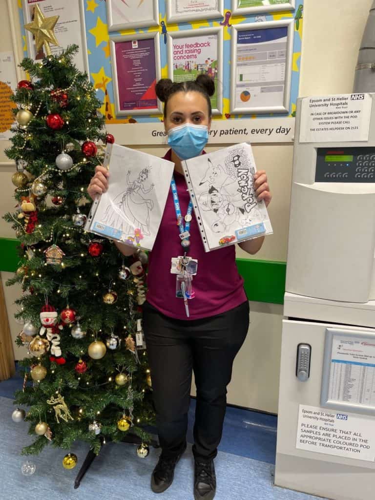 Play Specialist Sarah Montgomery holding colouring packs.